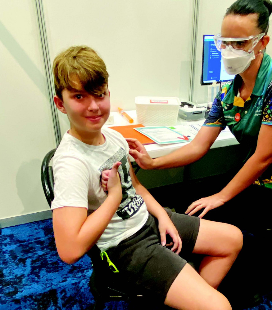Eli Doumani, 11, receives his first dose of the COVID-19 vaccine at Cairns Convention Centre