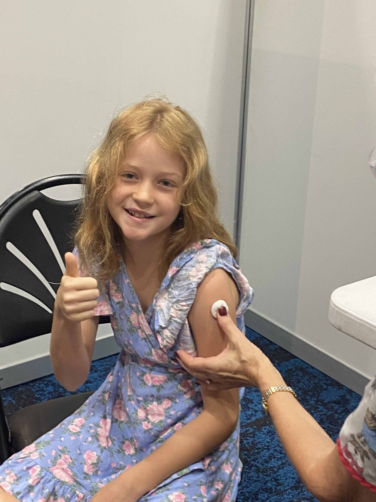 Lucy McDonnell, 10, receives her first dose of the COVID-19 vaccine at Cairns Convention Centre