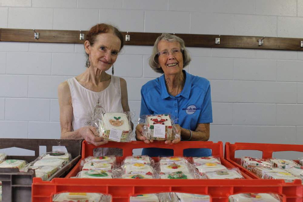 Joanne Cowell from QCDA & Joan Cadman from Meals on Wheels want to bring some joy to the elderly delivering 460 cakes with their meals this Christmas. Image: Isabella Guzman