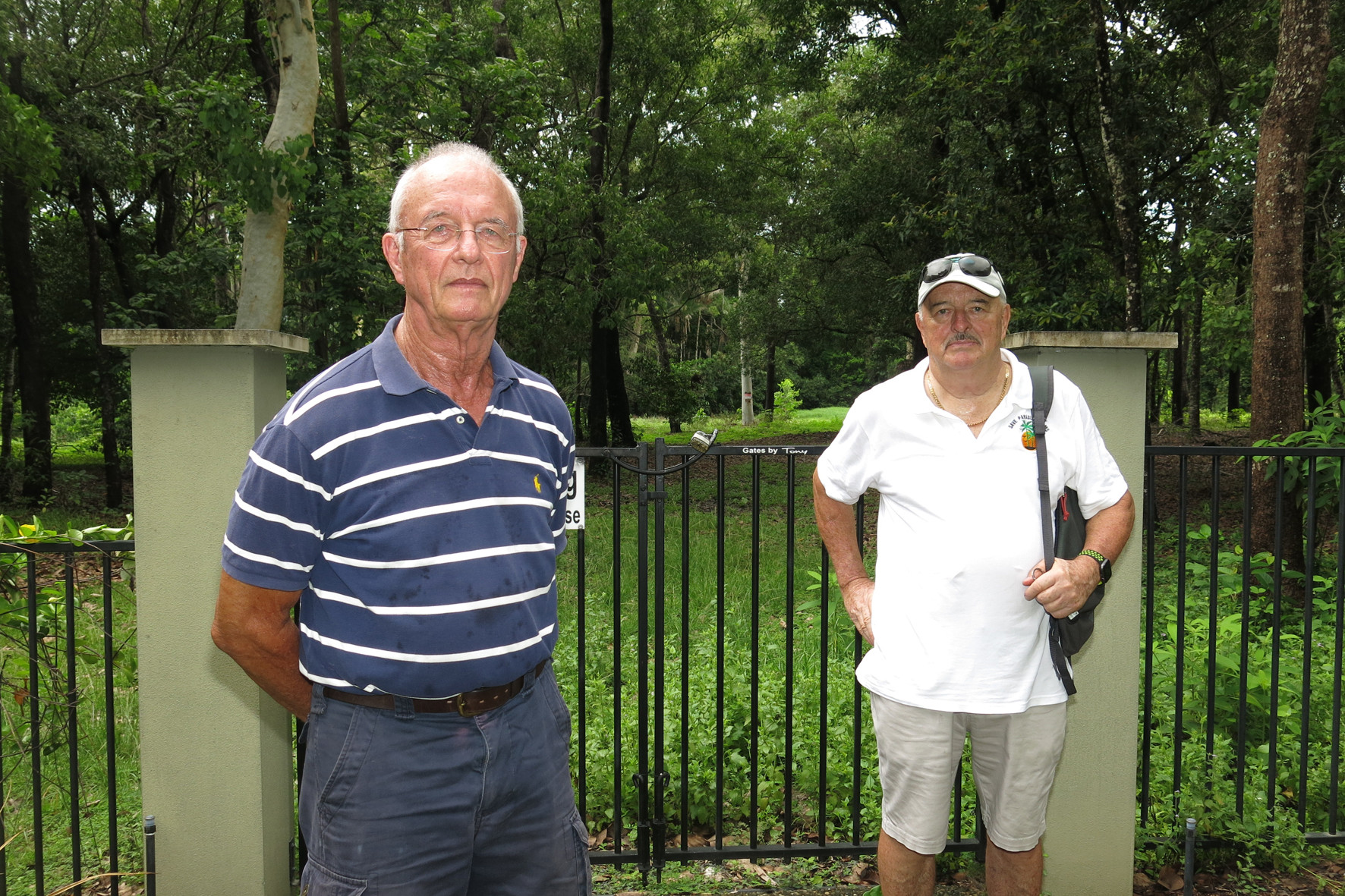 Paradise Palms residents Clive Abbott and Tony Richards at the back gate of their home, Keys Apartments, overlooking the former golf course