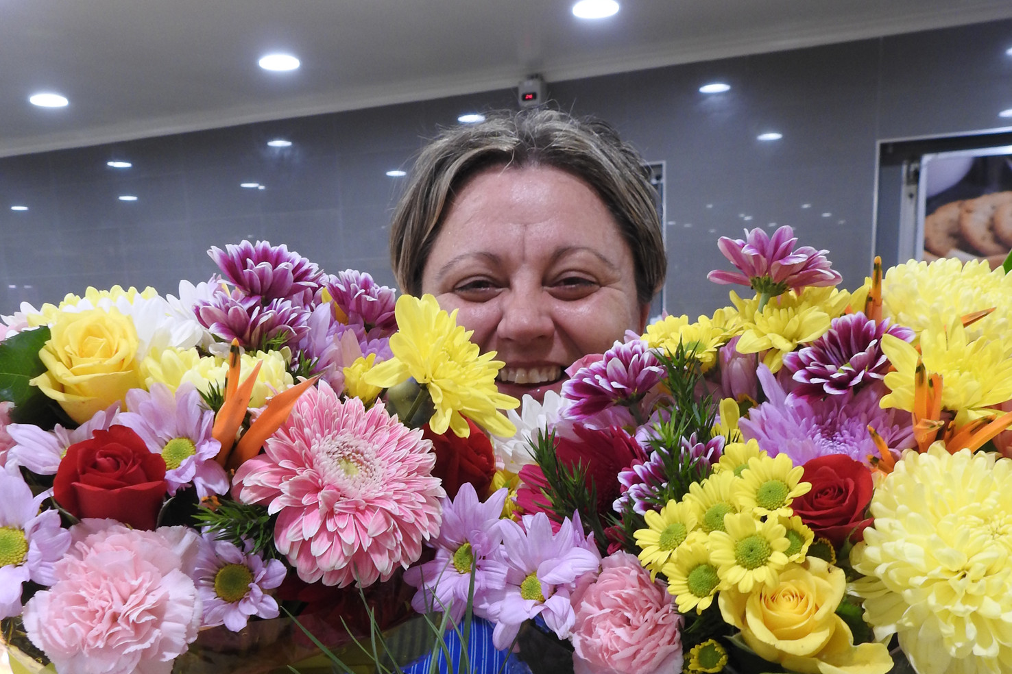 Gordonvale’s Cornetts IGA Supermarket staff member Michelle Tattain shows off some of the store’s 100 per cent locally-grown flowers.