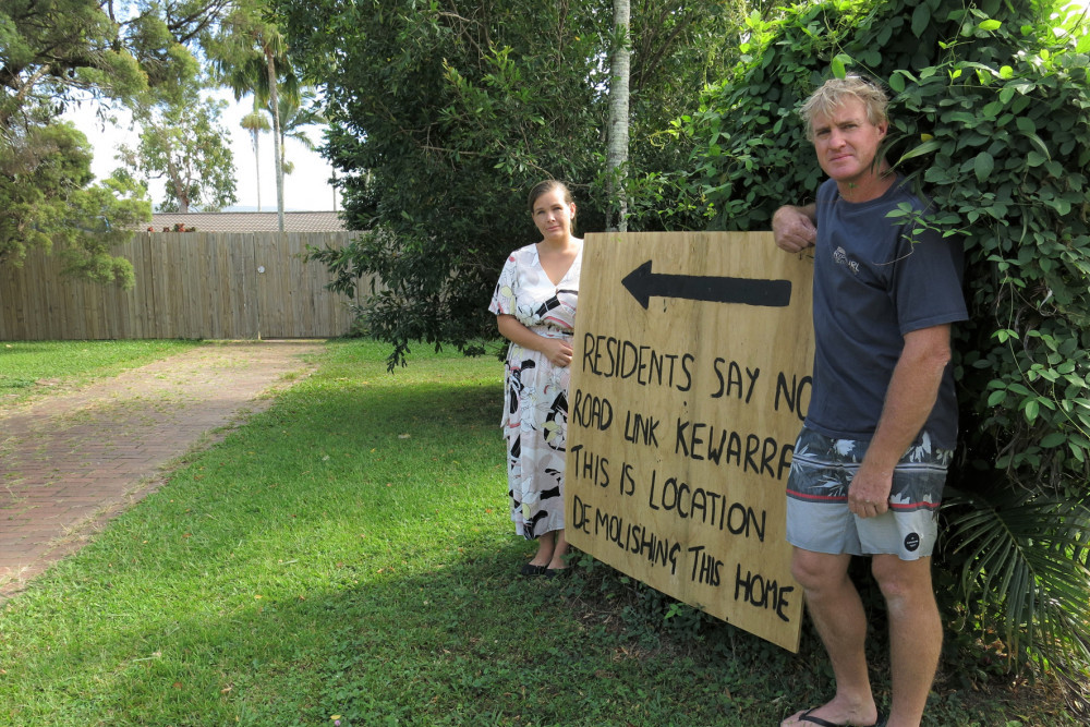 Next-door neighbour Calvin Fergie (right) has painted a sign to raise awareness about the location of the link road, which will see Shantel Watkins (left) and her three children evicted