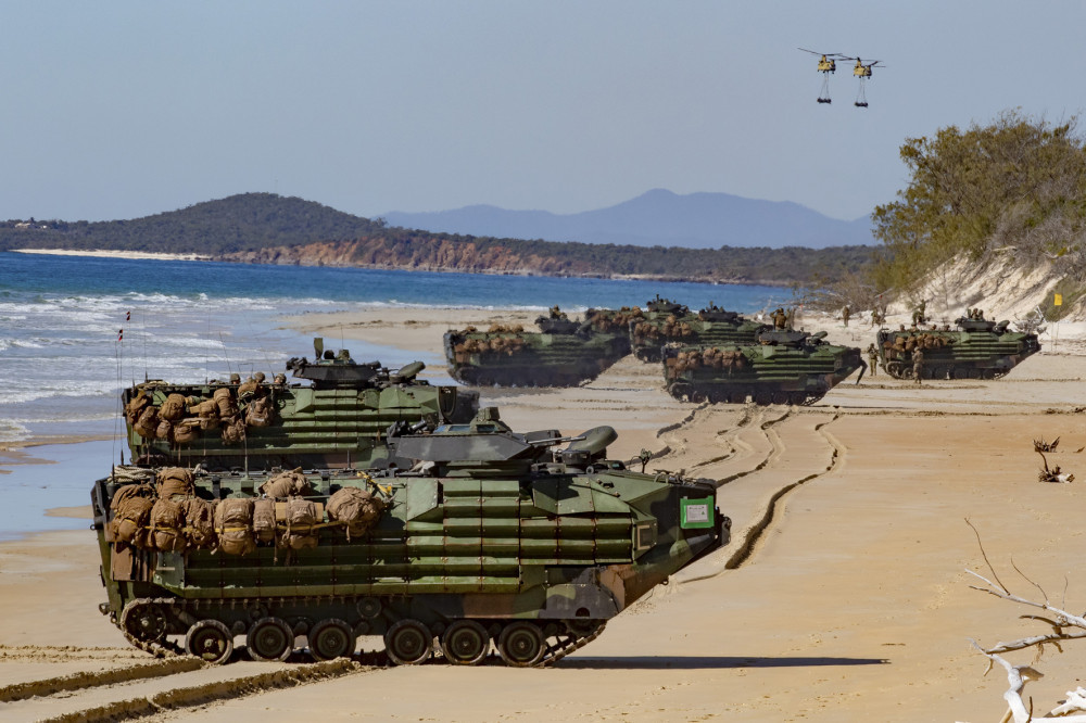 With U.S. Army CH-47 Chinook helicopters carrying artillery pieces on the horizon, U.S. Marine, amphibious assault vehicles stage on Langham Beach, Queensland, Australia, July16, during Exercise Talisman Sabre 2019. (U.S. Army Photo by Sgt. 1st Class Whitney C. Houston)