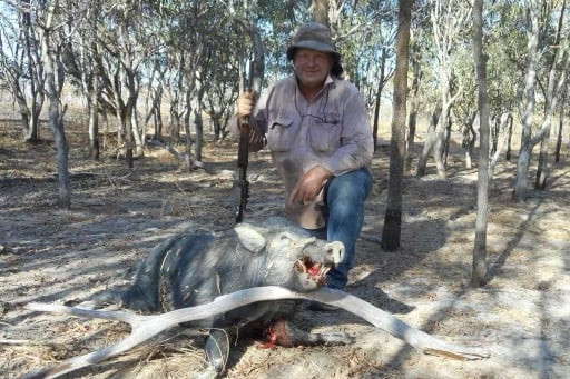 Member for Hill Shane Knuth kneeling next to a pig he shot. PHOTO: Supplied