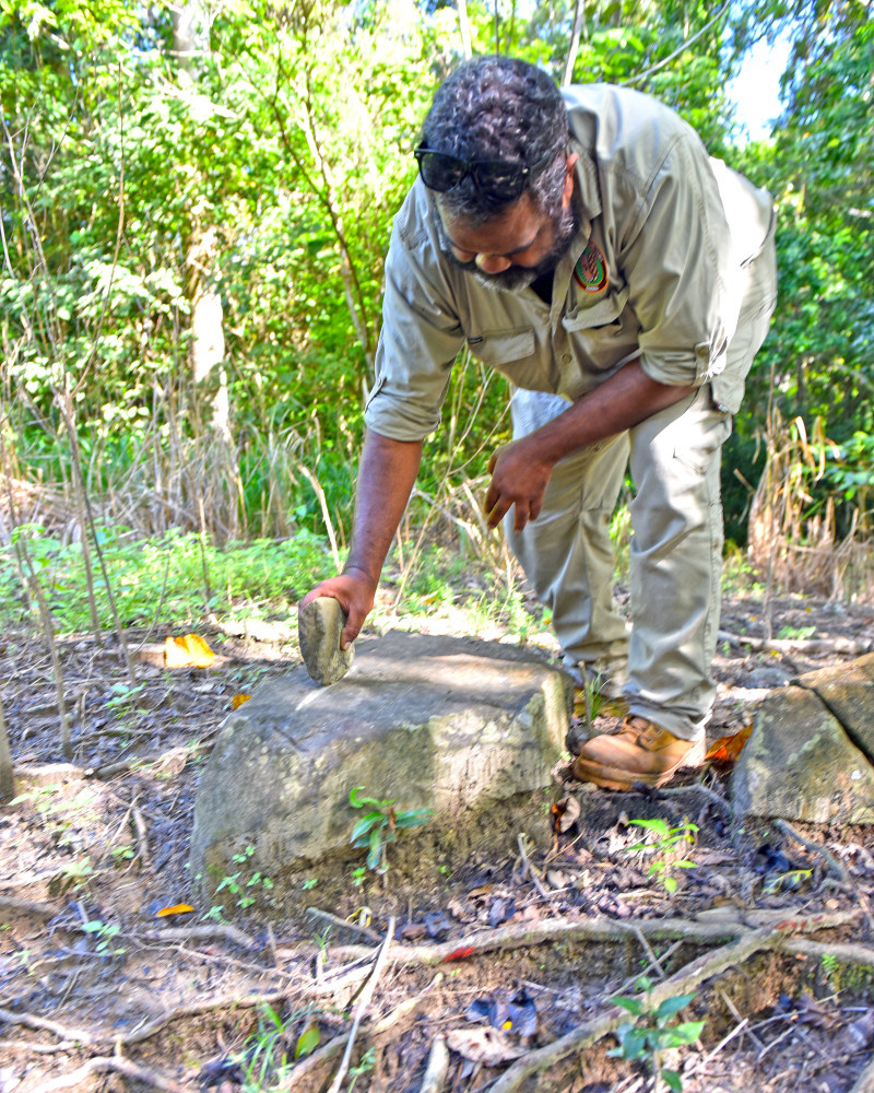 Trainee Ranger Luke Clubb demonstrating how a sharpening stone is used in Wooroonooran National Park