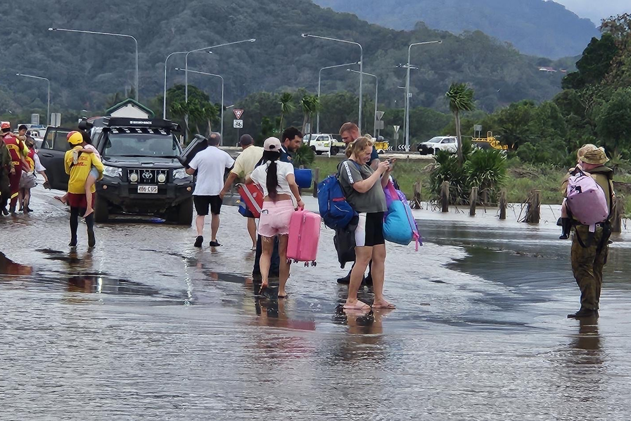 Australian Army soldiers from 51st Battalion, Far North Queensland Regiment, assist personnel from the Queensland Police Swift Water Rescue team and Surf Life Saving Queensland with recovery operations in Cairns' Northern Beaches on 18 December 2023.