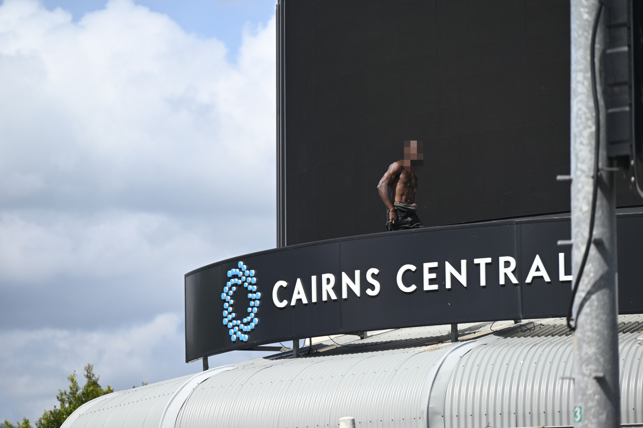 A man has climbed onto the roof of the Cairns Central shopping centre this morning. Picture: Isabella Guzman Gonzalez