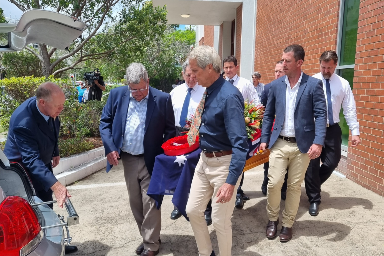 Pallbearers Peter Byrne, Agnes Stewart, David Pilcher, Jonathan Pilcher, Warwick Stewart and Maxwell Stewart carry the coffin of Kevin Byrne to the hearse.