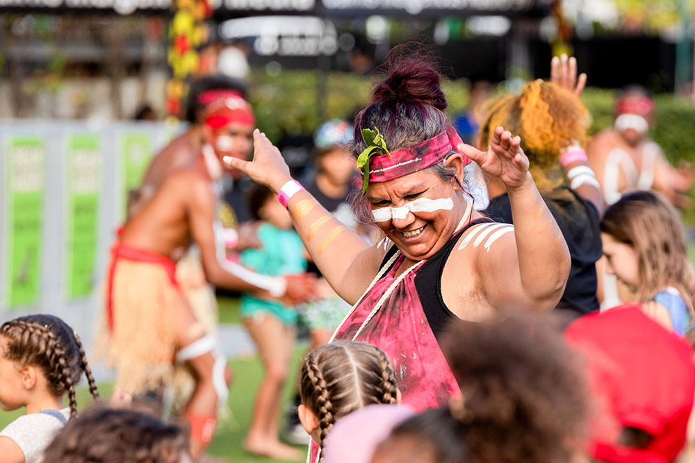 Festival-goers embrace the joy of movement and culture during a traditional dance at the 2024 Dream Aloud Festival in Cairns, celebrating First Nations connection and community. CREDIT: Supplied