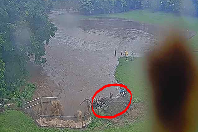 Children (circled) just centimetres from being swept into a large culvert. The group of children in the middle of the photo could also be easily swept away in the fast-flowing water.