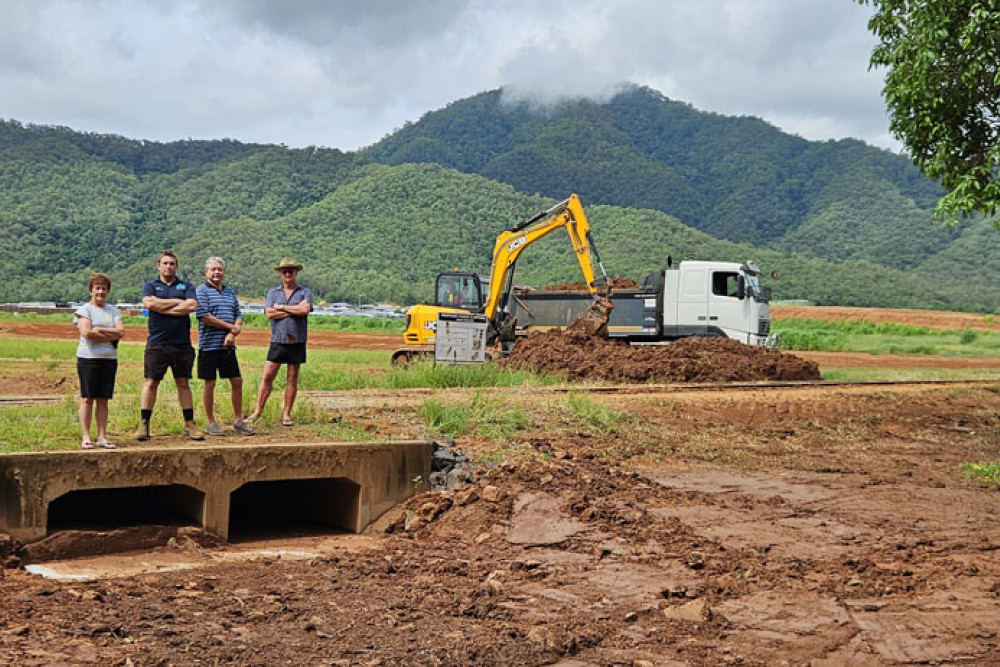 Meringa residents Janita Pavey (left), Myles Bryan, Len Pavey and Geoff Leigh above the drain which has flooded. They believe since the canefields were cleared for the Cutters Rise project flooding has increased in their street. Picture: Nick Dalton