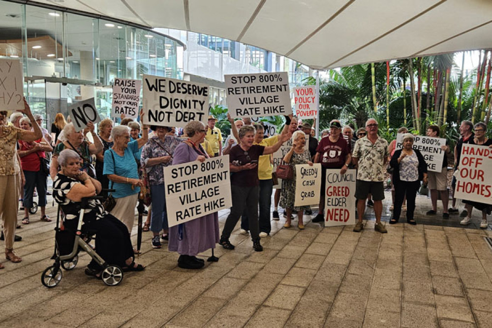 Retirement village resident Colleen Duplock leads a chant at a protest of 100 pensioners at the Cairns Regional Council chambers on Wednesday morning. Picture: Nick Dalton