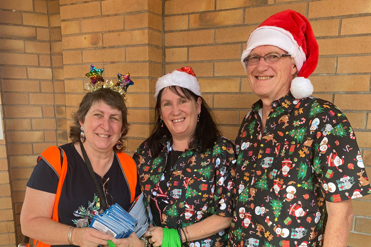 Childs World Educator Jodie Dolan with Neil Graham and Raelene Rickets handing out goodies for children at Joy to the World at the Cairns Showgrounds