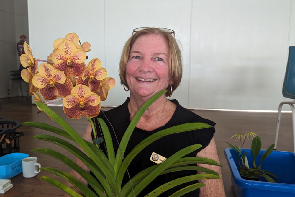 North Queensland Orchid Society member Dawn Abercrombie with her winning orchid in the novice popular vote category.