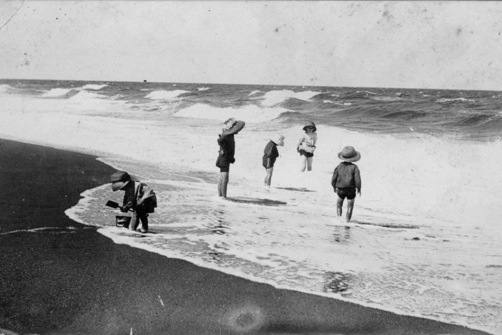 Children playing in the surf in the Cairns district, ca. 1914. Although the surf looks to be quite menacing, the children were very well protected from the sun with their hats. Courtesy State Library of Queensland