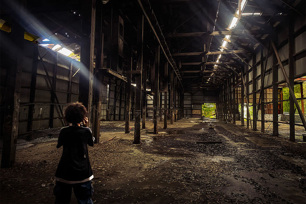 Young photographer Riley Stannard takes a picture of the abandoned White’s Shed at the Port of Cairns, documenting the region’s history and what is left behind. Picture: Laura Baranyl