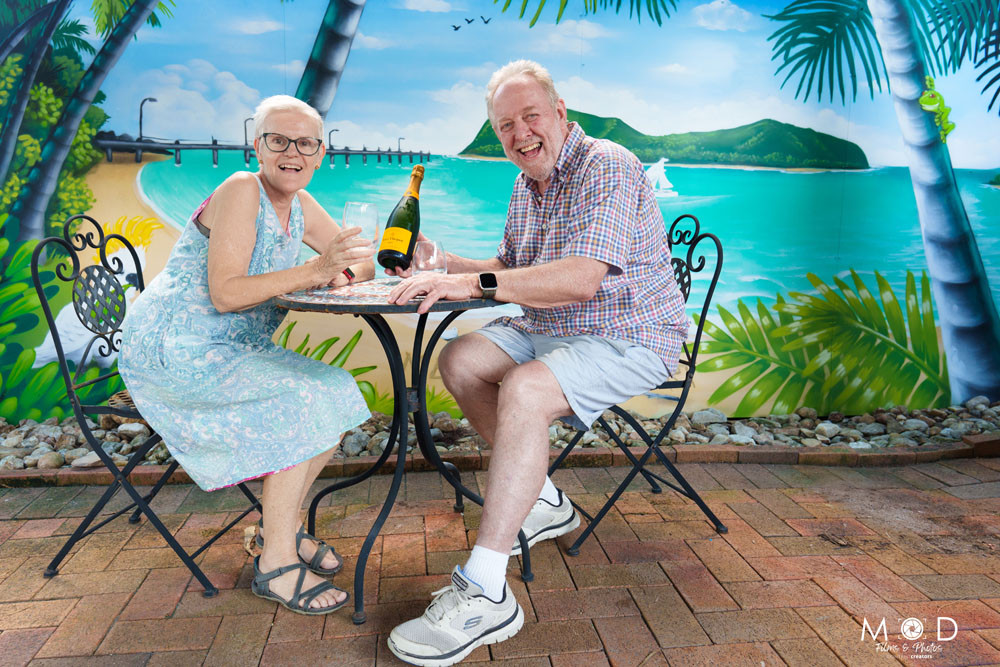 Margaret and Stephen Coop toast their colourful new mural at Melaleuca Resort, Palm Cove. Inset: Artist Daniel Wallwork. Pictures: Coli Pett/Mod Films and Photos