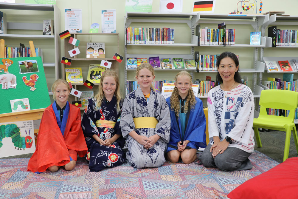 Japanese teacher Hiromi Wall and Wonga Beach State School students (from left) Sophia, Maya, Rhylee and Zamirah hosted a Bilingual Storytime at Mossman Library. Inset: The Very Hungry Caterpillar and other well-known books have been read during the Bilingual Storytime sessions at Mossman Library.