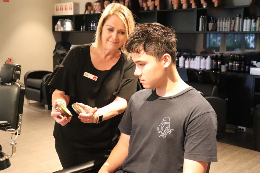 TAFE Queensland senior hairdressing and barbering teacher Trish Nielsen advises a male student on the best skincare products for his skin.