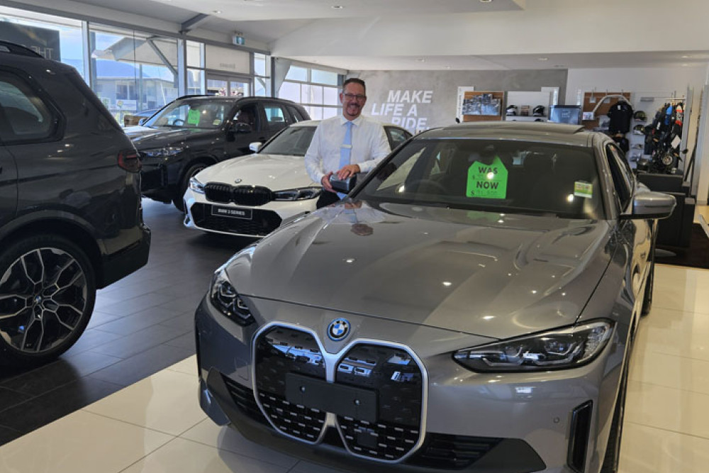 Westco BMW sales manager Grant Woolcock in the Newell St showroom, with an i4 eDrive 35 reduced to $91,800. Picture: Nick Dalton