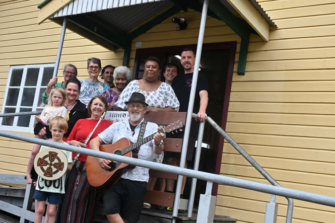 Machans Beach Community Association volunteers Mary Brodie (back left), Michelle Milne, Centacare representatives Patrick Sim, volunteer Mary Saveka, president Letitia Choppy, Centacare representative Jarred Bromley, Mayhem at Machans owner Greg Lemont, Skye Hinton (front left) with her children Angel and River and local folk duo Wind and Wood, Morag and Trevor Gane. Picture: Maddy Gavin