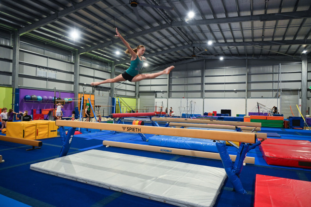 Toni McQueen giving her best jump on the beam. Inset: the gymnasts at South Cairns Gymnastics are enjoying the new equipment. Pictures: Maddy Gavin