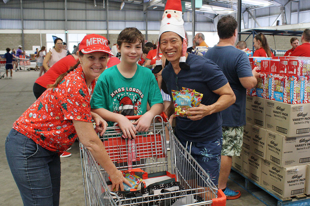 Natasha, Jarred, 10, and Trevor Garvey at the hamper packing at the Cairns Showgrounds. Picture: Cairns Regional Council