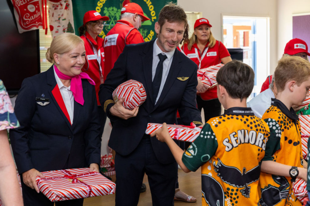 Captain Peter Robinson and flight attendant Bridgette Harrison hand out gifts at Mossman State School. Picture: Supplied