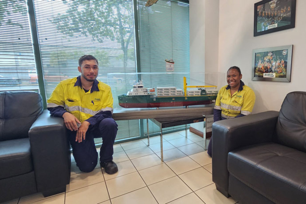 New employees at Sea Swift Rhys O’Sullivan and Danielle Atu in front of a model of the firm’s new Newcastle Bay purpose-built cargo ship. Picture: Nick Dalton