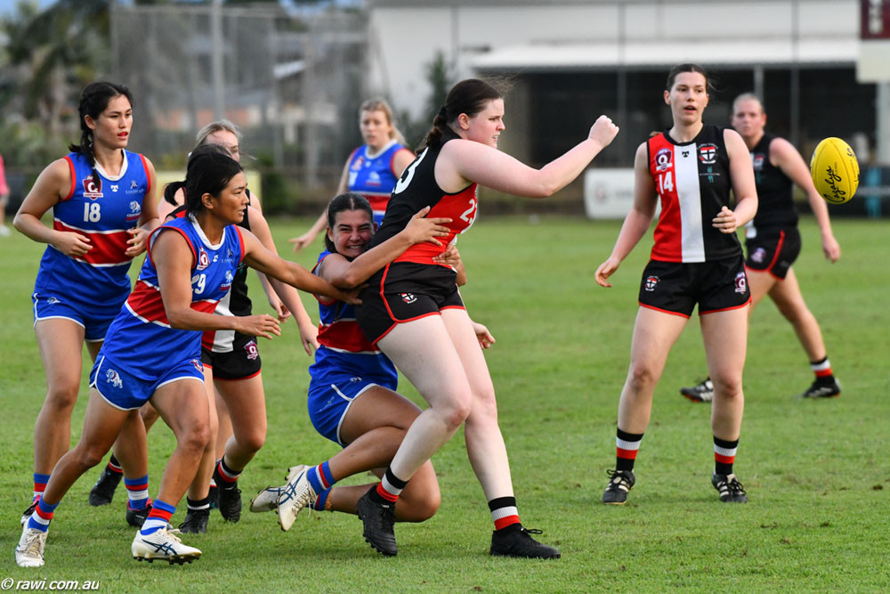 Sarah Heard of the Cairns Saints fending off a pack of Bulldogs at Griffiths Park. Below: Grace Frost continues her cracking start to the season with Centrals Trinity Beach Bulldogs. Pictures: RAWI/AFL Cairns