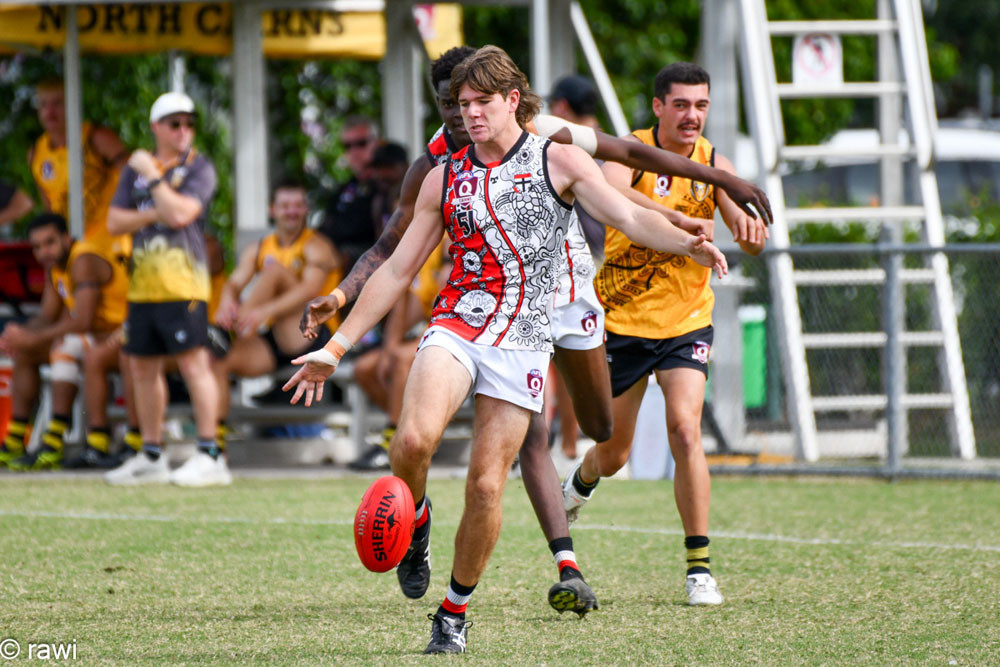 Rising star nominee Bailey Wallace gets a kick away under pressure during a tightly contested match. Picture: rawi/AFL Cairns