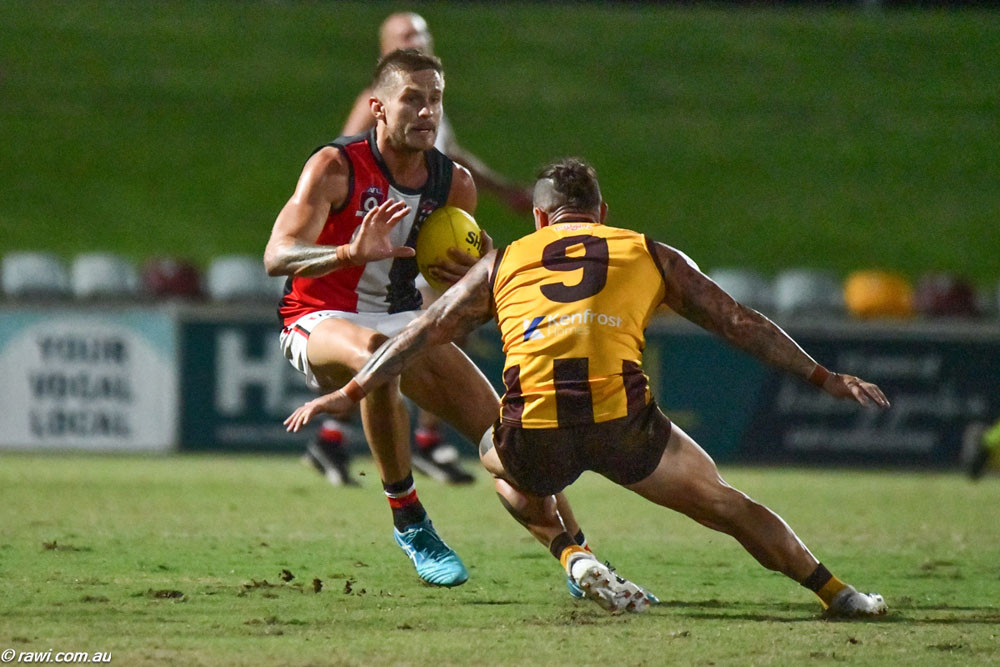 Cairns Saints skipper Chris Novy takes on James Boyd of the Manunda Hawks. The pair had a massive 21 clearances between them in the Battle of Manunda on Anzac Day. Below: Zavier Ballis for the Saints competes with Justin Langham of the Hawks at the Battle of Manunda at Cazalys on Anzac Day. Pictures: RAWI/AFL Cairns