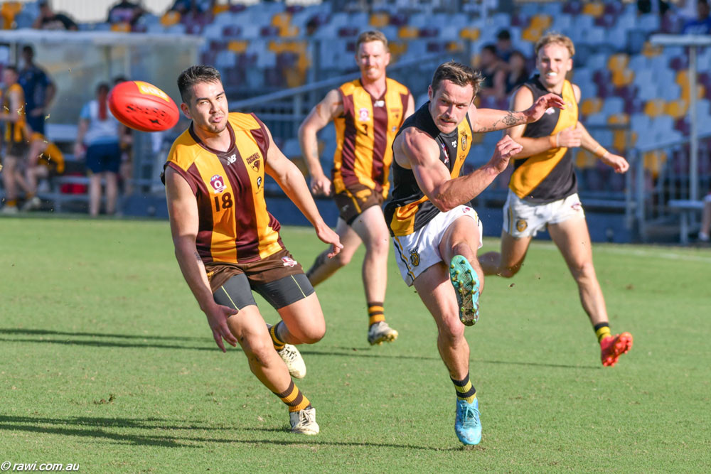 The Tigers’ Dan Jackson gets the kick away ahead of the Hawks’ Jack Lowe. Below: The Tigers’ Darcy Keast and Rory Tarlinton are out to spoil Hawk Ezekial Frank’s day. Pictures: RAWI/AFL Cairns