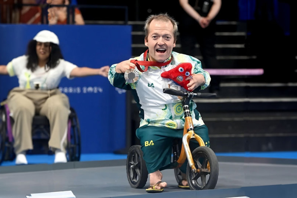 Grant ‘Scooter’ Patterson with one of his bronze medals and coach Andrew ‘Herbie’ Howard at the Paris Paralympics. Above right: Scooter and Herbie with his FNQ Swimming team mates before leaving for Paris.