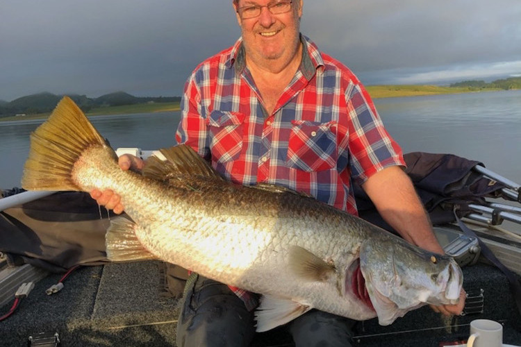 Mark Hennessy with his giant barra on Lake Tinaroo.