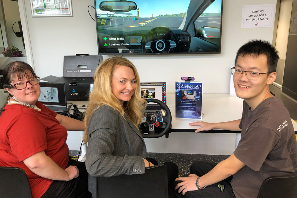 Demelza Werly guides JCU’s innovation facilitator Dr Samantha Horseman and data science student Yihong Mei through the driving simulator she has developed. Picture: James Cook University
