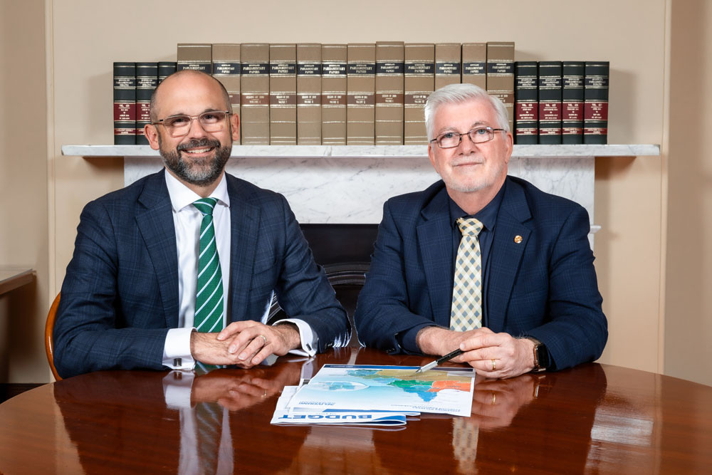 State treasurer David Janetski (left) goes through the state budget papers with Member for Mulgrave Terry James at Parliament House. Picture: Supplied