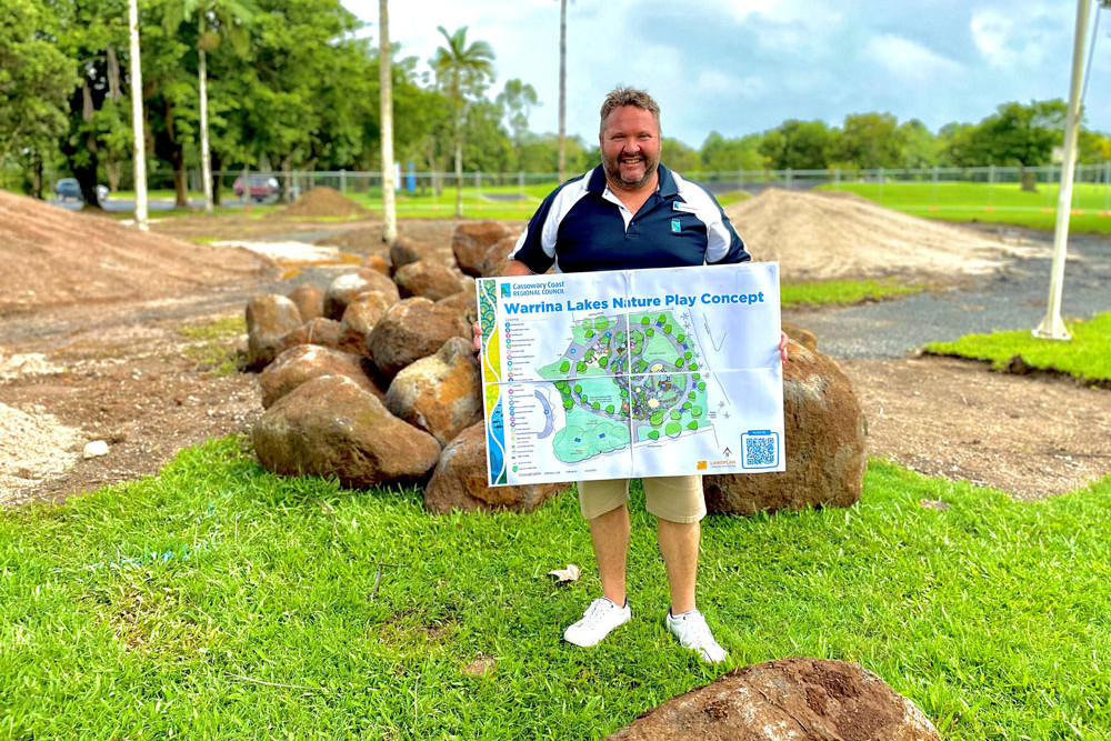 Cassowary Coast deputy mayor Nicholas Pervan on site with a plan of the Warrina Lakes’ nature play area. Picture: Cassowary Coast Regional Council