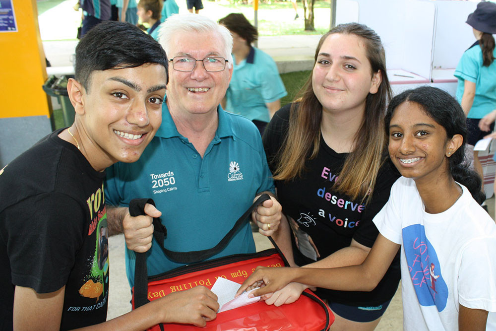 Acting mayor Terry James with St Andrew’s College candidates Aiden Senarantine (left), 15, Molly Ben Ezra, 15, and Serah Joju, 13, casting their vote at the school. Picture: Cairns Regional Council