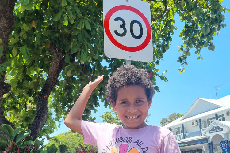 April (surname withheld) in front of one of the new speed-limit signs on Macrossan St but the furore is over (inset) the white on red road markings. Main picture: Dave Lornie. Inset: Gary ‘Gazza’ McIlroy