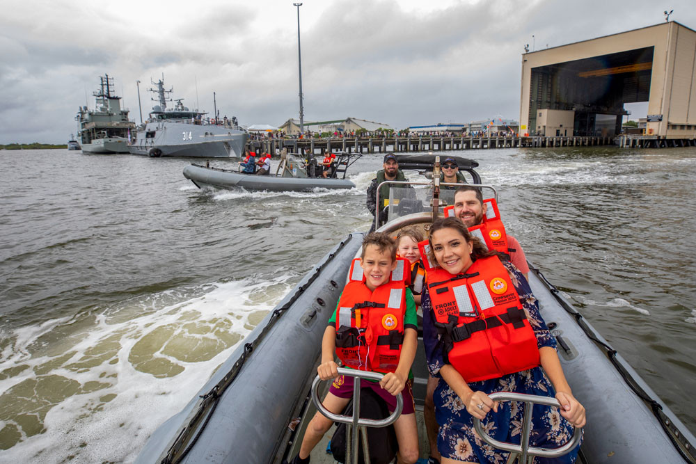 Cairns residents (front to back) Nate, Terri, Solomon and James go for a ride in an inflatable boat at last year’s HMAS Cairns open day. Picture: LSIS Shane Cameron