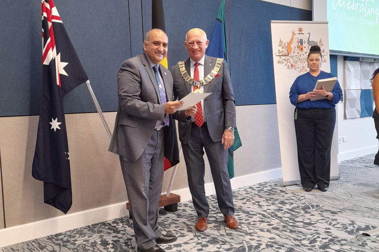 Nauman Abbasi receives his citizenship award from Cairns Mayor Bob Manning