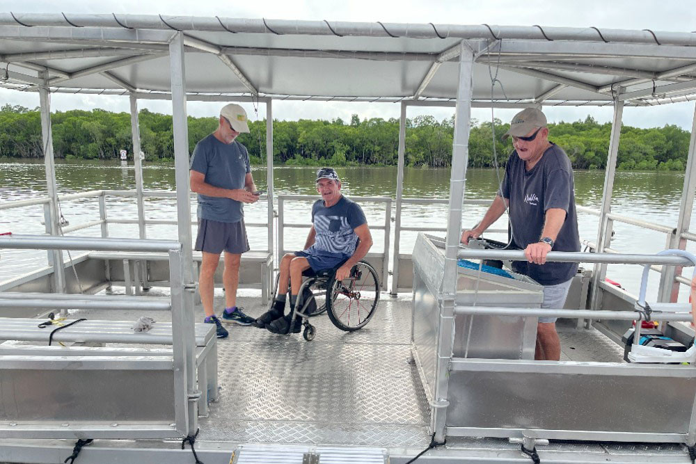 Sailability community members Sandy McEachan (left), Bob Moore and Mark Grimston test out the new 12-person aluminium pontoon boat. Picture: Sailability Cairns