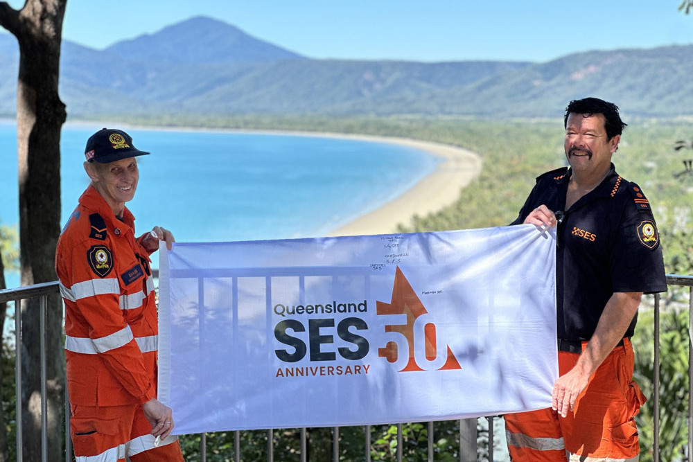 Mossman SES members Sharm Giles and Stephen Bigby with the 50-year flag at Flagstaff Lookout, Port Douglas. Picture: Facebook