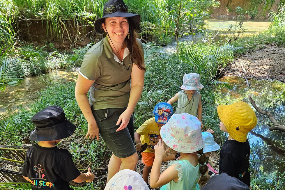 Small Steps senior early childhood teacher Nicole Deloryn with her youngsters participating in Bush Kindy. Picture: Supplied