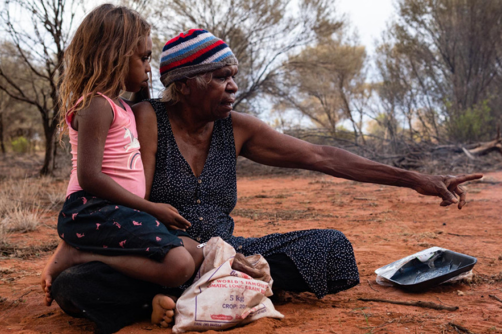 Yuendumu, NT Australie, February 15 2020 : Aborigines Warlpiri in the bush. Family, grandmother and granddaughter, after hunting honey ants