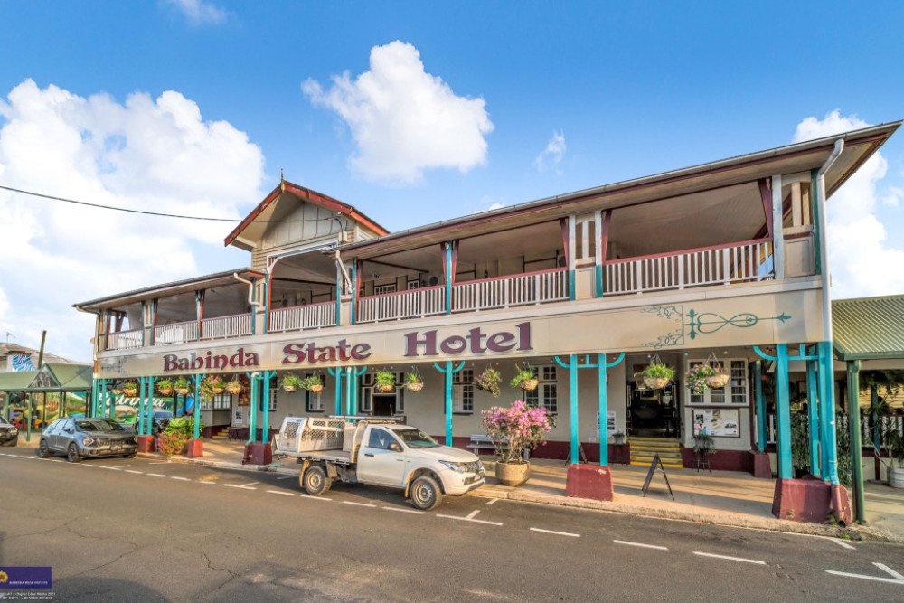 The exterior of the Babinda State Hotel (top), the ornate staircase inside the hotel (above, left) and the main bar (above, right).