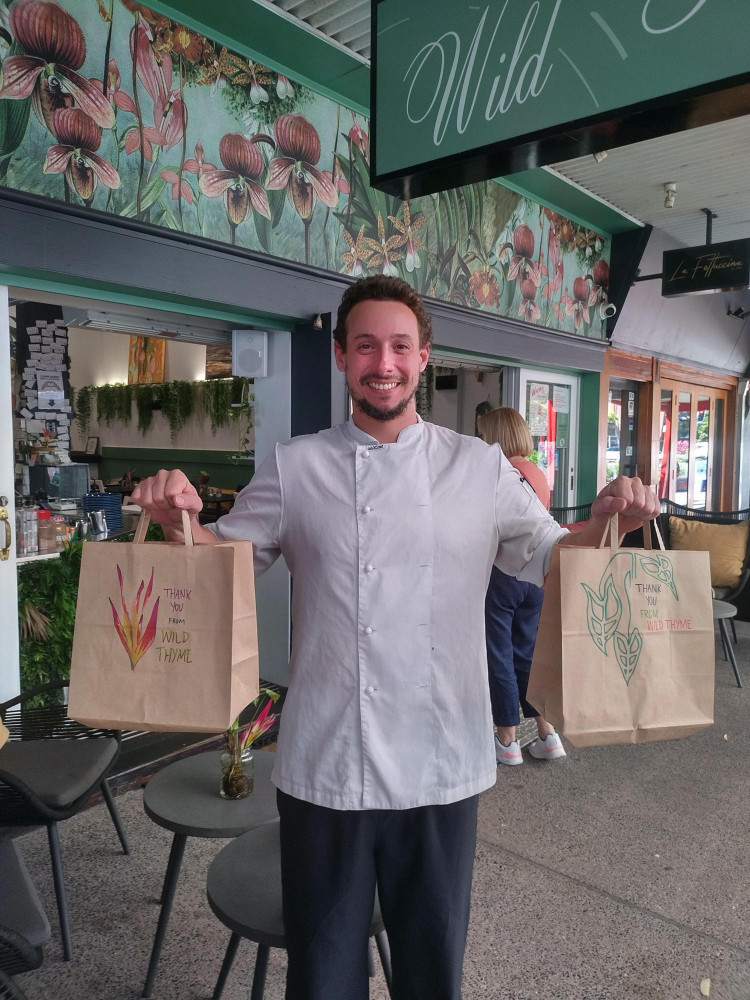 Chef Carlos from Wild Thyme, with meal pack donations for those in need