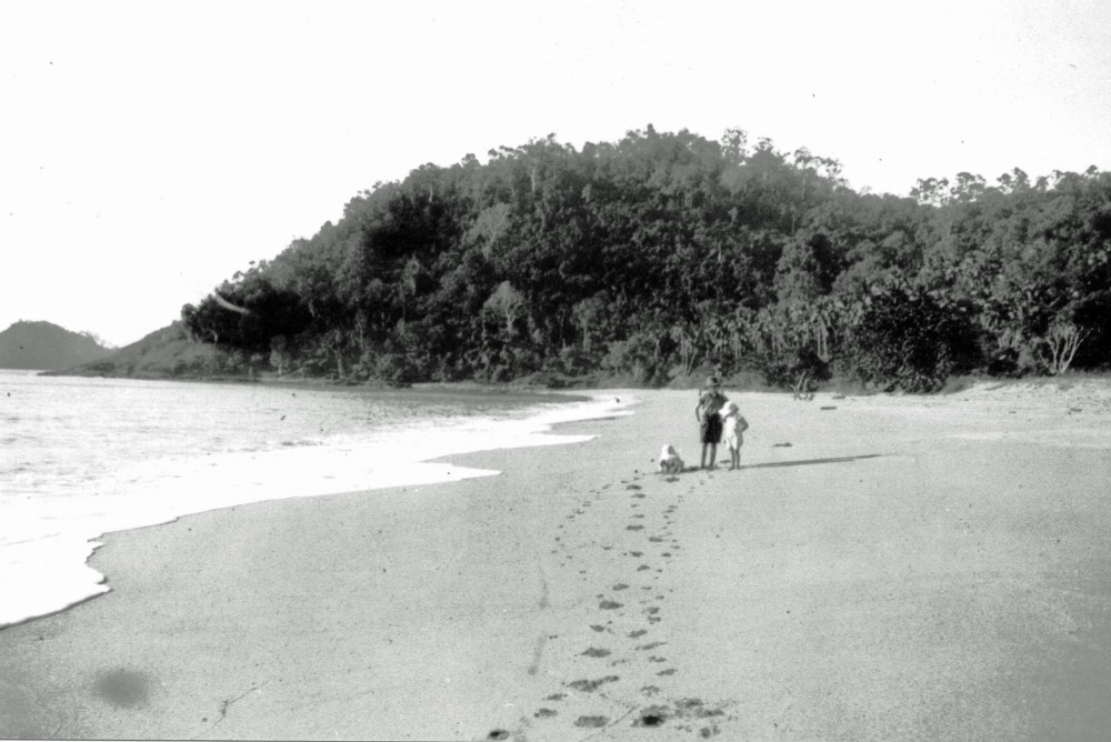 Ian McGuigan with his twin sisters, enjoying a walk along the sand at Trinity Beach, c. 1937.