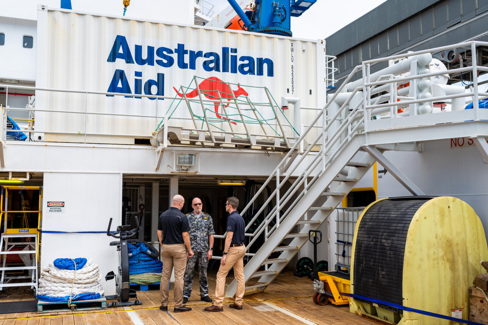 Royal Australian Navy Lieutenant Commander Gregory Wilson, RAN, speaks with Australian Army Major Samuel McKenzie and Captain Zach Holt from the 2nd Battalion, The Royal Australian Regiment, during their tour of ADV Reliant.